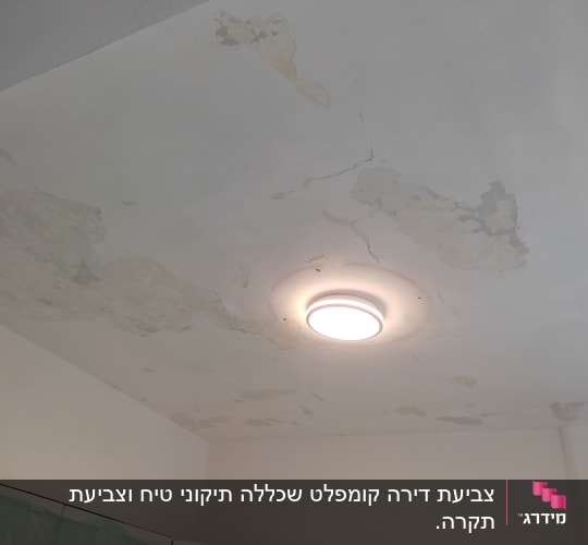 תקרה מתקלפת עם סדקים סביב מנורה עגולה